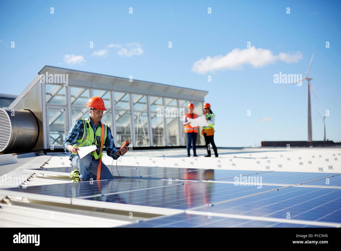 Engineer testing solar panels at sunny power plant Stock Photo