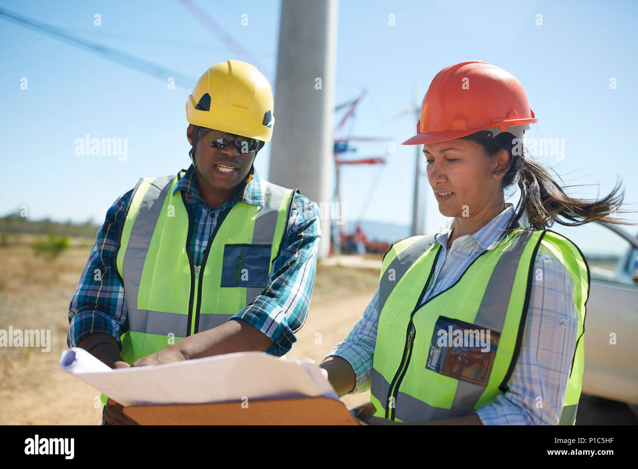 Engineers reviewing blueprints at power plant Stock Photo