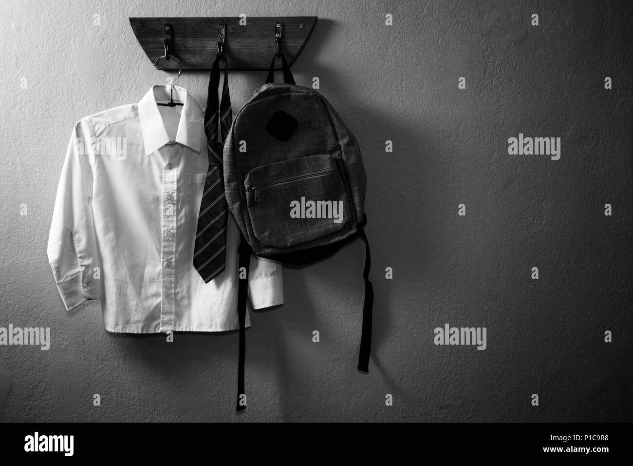School uniform and schoolbag hanging on hook Stock Photo