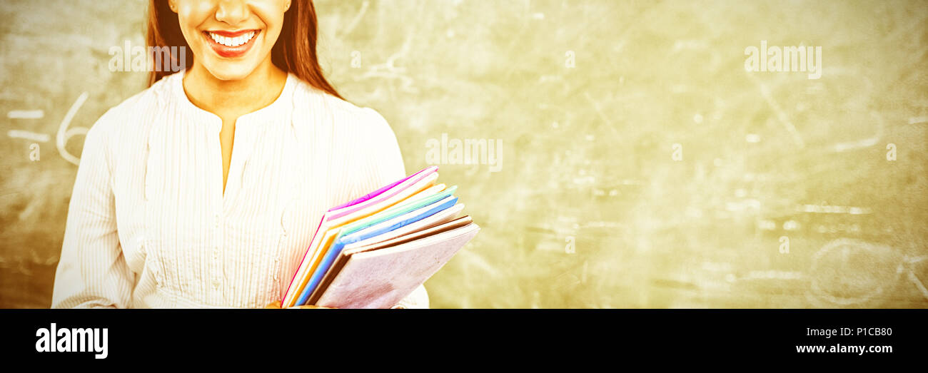 Teacher standing against blackboard Stock Photo