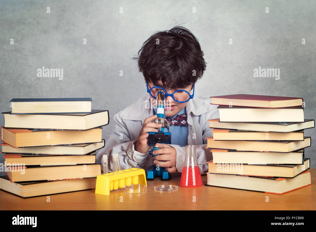 boy is making science experiments on gray background Stock Photo