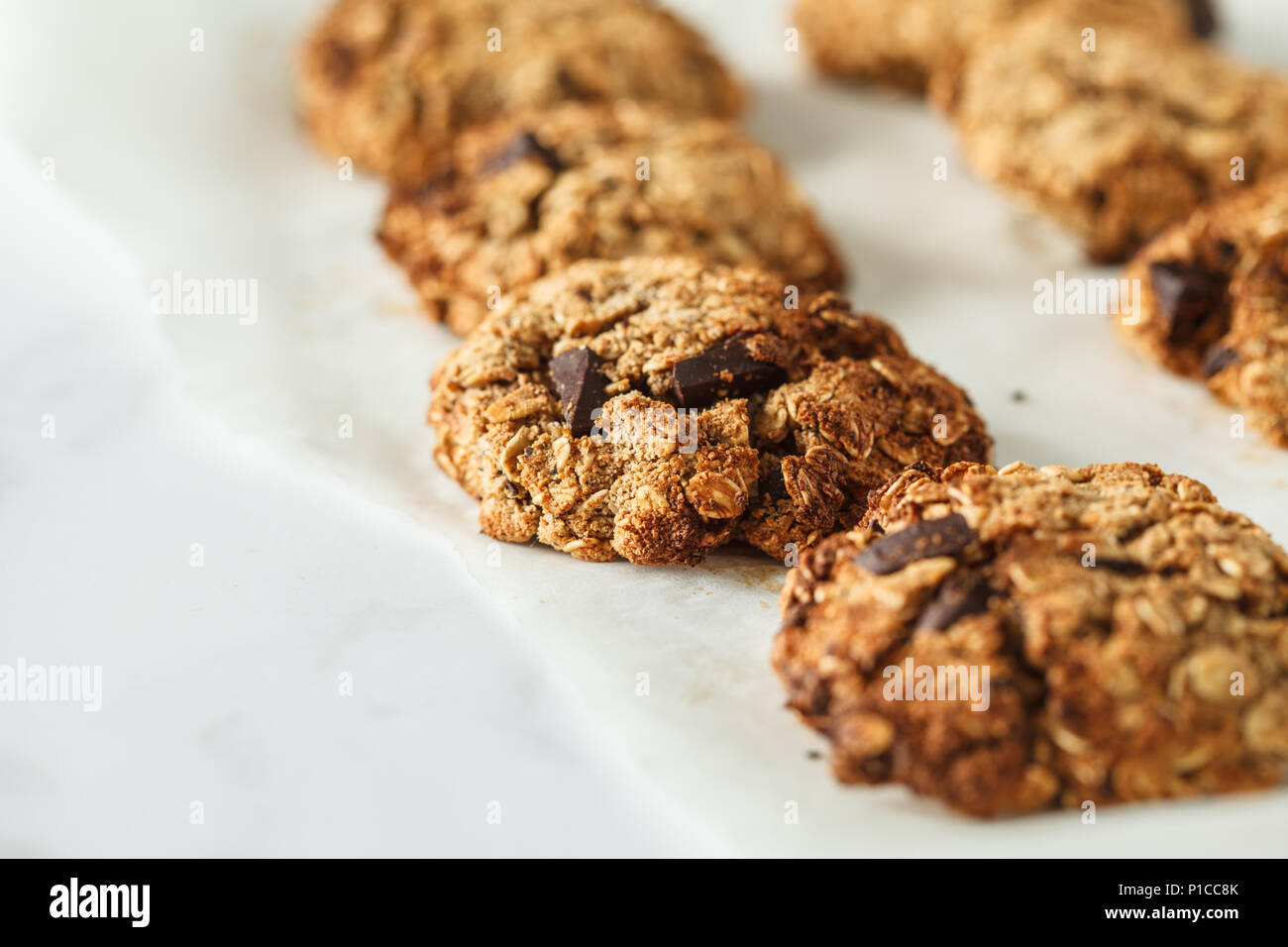 Vegan oatmeal cookies with chocolate on a light background. Food blog style concept. Stock Photo