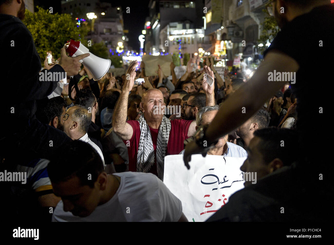 Ramallah, Palestinian Territories, West Bank. 10th June, 2018. Men carrying signs with the images of Razan Al-Najar, a nurse killed by Israeli forces during clashes on the Israeli-Gaza border, lead a march in protest of Mahmoud Abass.Palestinians gathered in Al-Manara Square to march in protest of Mahmoud Abass and the Palestinian Authority. A group of pro-Abass supporters briefly scuffled with protesters, however the march remained peaceful after. Credit: Matthew Hatcher/SOPA Images/ZUMA Wire/Alamy Live News Stock Photo