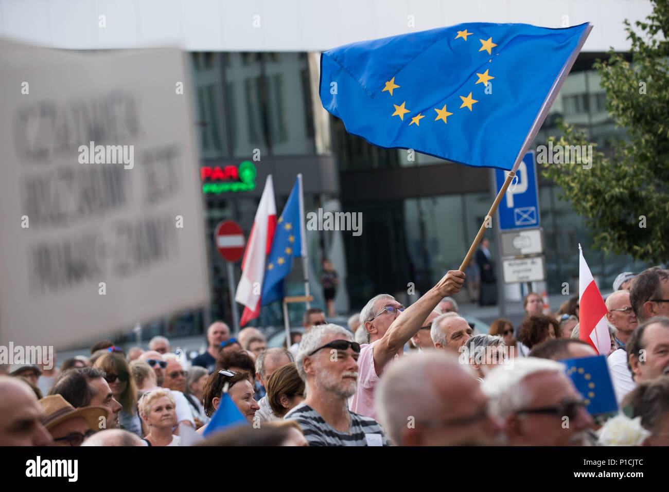 A man waves European Union Flag during a protest in favour of  European Commission move urging EU leaders to press forward with disciplinary action against Poland for allegedly violating rule-of-law standards in front of the Courts in Krakow. In December, the European Commission launched an Article 7 disciplinary process, which, in theory, could lead to the suspension of Poland’s EU voting right. The European Commission  gave Poland until late June to reverse the reforms introduced by the current government but no changes were made until today. The protests are organized by KOD ( Committee for Stock Photo