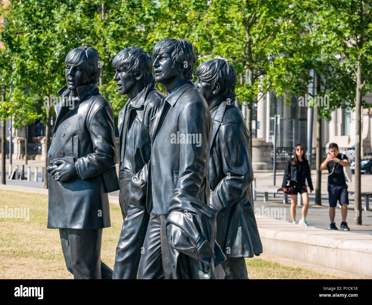 Pier Head, Liverpool, England, United Kingdom, 11th June 2018. UK weather: sunshine on the Mersey. A beautiful sunny Summer day along the River Mersey in Liverpool today for visitors to the popular Beatles statue by Andy Edwards, which reflects a real photo shoot from the past Stock Photo