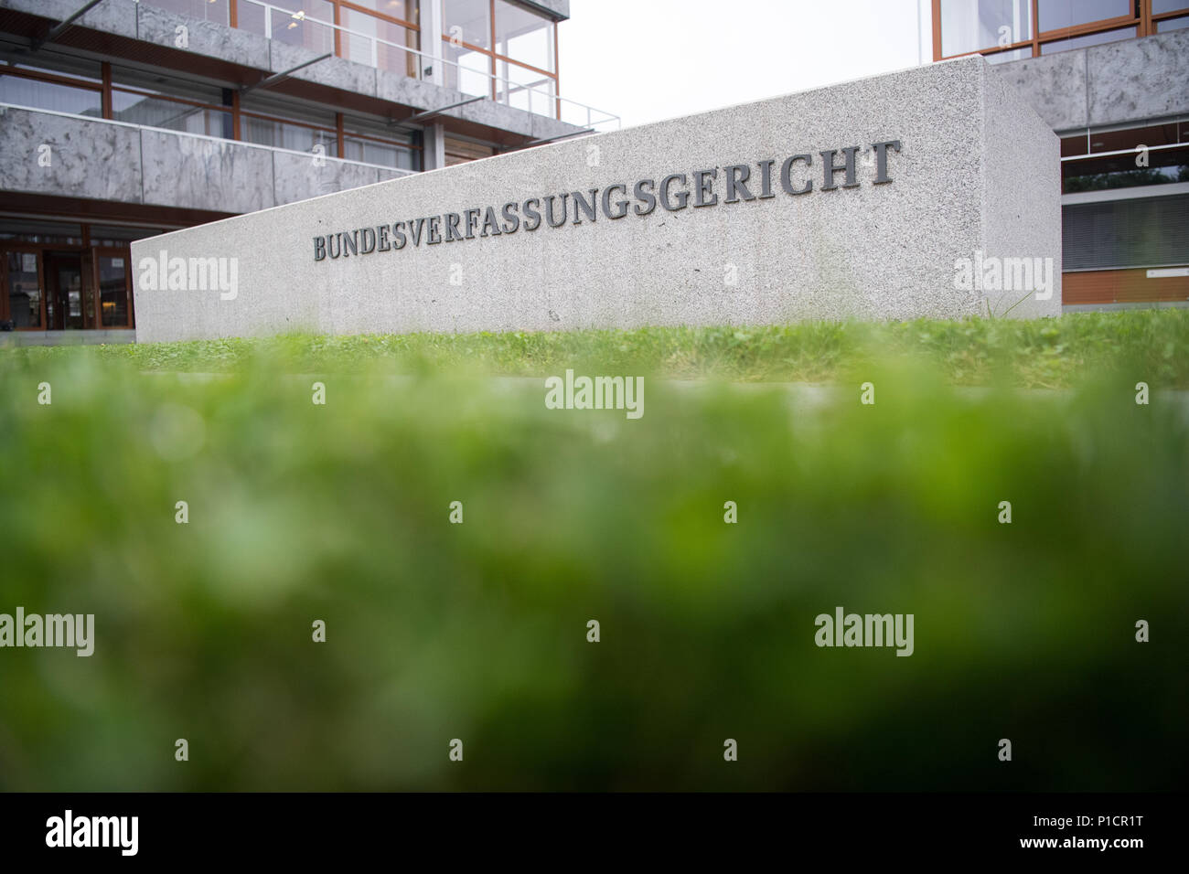 12 June 2018, Germany, Karlsruhe: A sign reads 'Bundesverfassungsgericht' (lit. Federal Constitutional Court) outside the Federal Constitutional Court on the day of the pronouncement of judgement on the striking ban for civil servants. Four teachers who are civil servants brought an action against disciplinary measures. They participated in warning strikes and were punished for doing so. The hearing took place on 17 January. Photo: Sebastian Gollnow/dpa Stock Photo