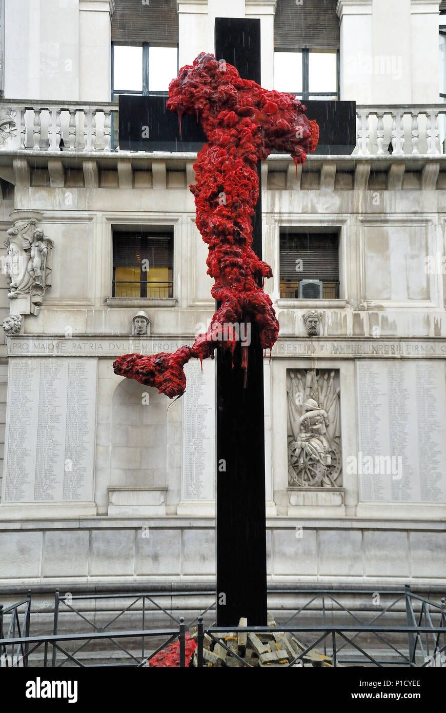 Padua, Italy. June 12th, 2018. Crucifix Italy, artistic installation by Gaetano  Pesce. A cross in black wood on which which an Italy is dripping blood,  Sardinia falls to the ground, together with