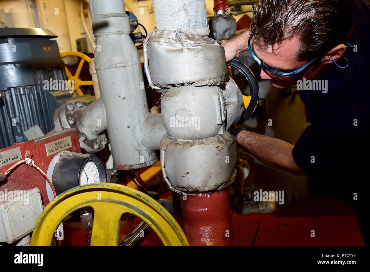 161014-N-QV906-032 SUVA, Fiji—Contracted mariner Steven Benavides, qualified member of the engine department aboard maritime prepositioning force ship USNS Pililaau (T-AKR 304), opens a lubricant valve before starting Pililaau's main engine during KOA MOANA 16-4, Oct. 14.  The KOA MOANA (Ocean Warrior) exercise series seeks to enhance senior military leader engagements between allied and partner nations with a collective interest in military-to-military relations and to discuss key aspects of military operations, capability development, and interoperability.  (U.S. Navy photo by Petty Officer  Stock Photo