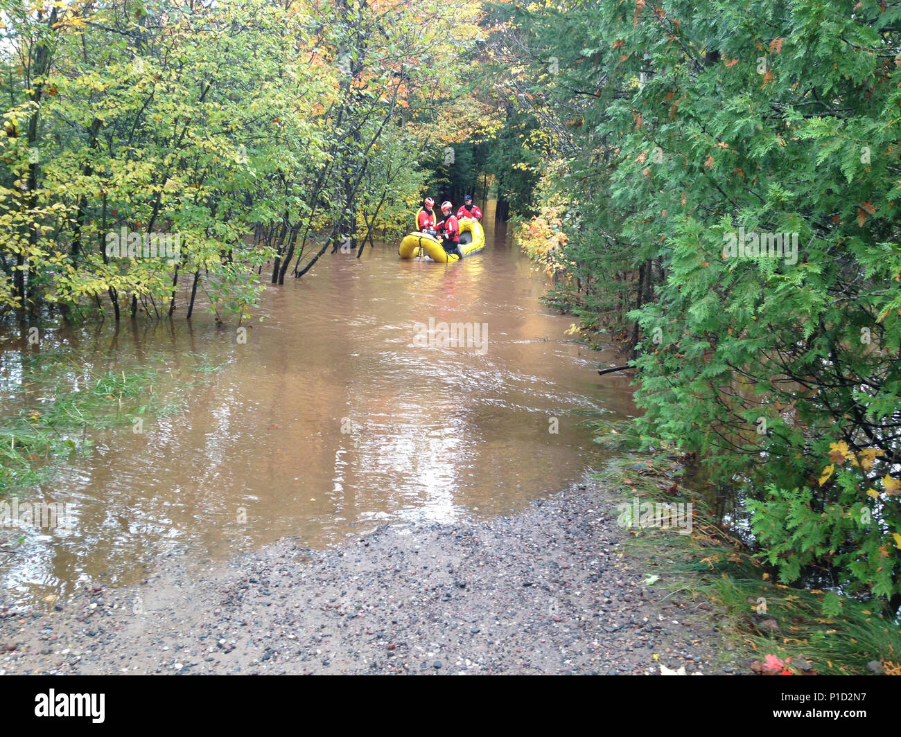Petty Officers Gerard Gagnon, Tim Koscielny and Terry Bailey launch a rescue skiff Oct. 18 ,2016, down a flooded driveway near the Chocolay River in Marquette, Michigan. Crews worked with the Chocolay Fire Department evacuating citizens from their homes located along the river. (U.S. Coast Guard photo by Station Marquette) Stock Photo