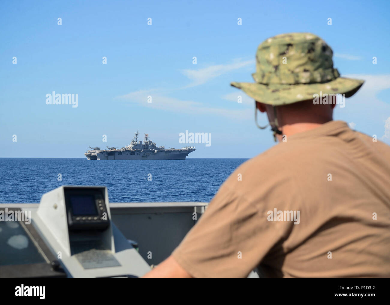 161013-N-RL456-0893 CARRIBEAN SEA (Oct. 13, 2016) Petty Officer 1st Class Imre Balazsi, attached to Assault Craft Unit 2 observes the approach to the amphibious assault ship USS Iwo Jima (LHD 7) from landing craft utility (LCU) 1643. Iwo Jima and the 24th Marine Expeditionary Unit are underway to provide disaster relief and humanitarian aid to Haiti following Hurricane Matthew. (U.S. Navy photo by Petty Officer 2nd Class Hunter S. Harwell/Released) Stock Photo