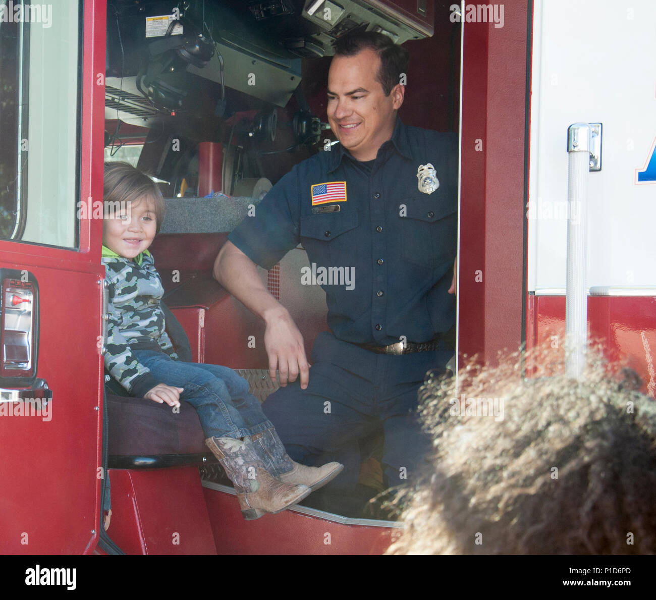 A student from the Child Development Center aboard Marine Corps Logistics Base Barstow, Calif., sits in a firetruck with Fire Prevention Officer Paul Aguilar as part of the Fire Prevention Week activities Oct. 11. Stock Photo