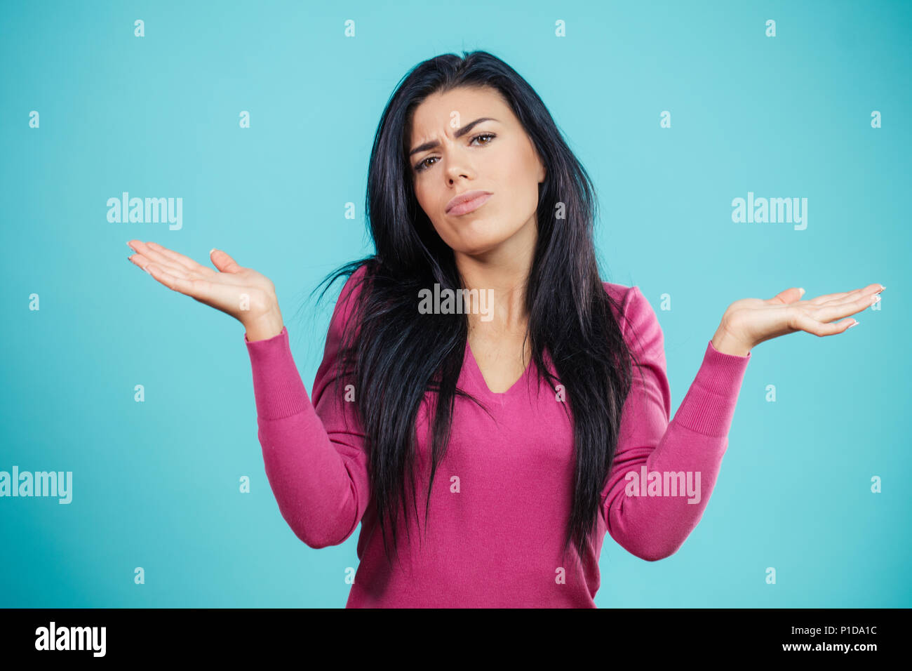 confused pretty girl shrugging her shoulders Stock Photo