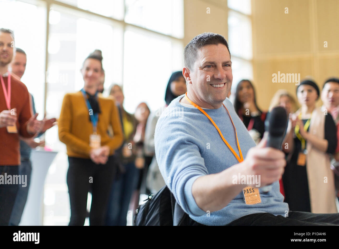 Smiling male speaker answering audience questions Stock Photo