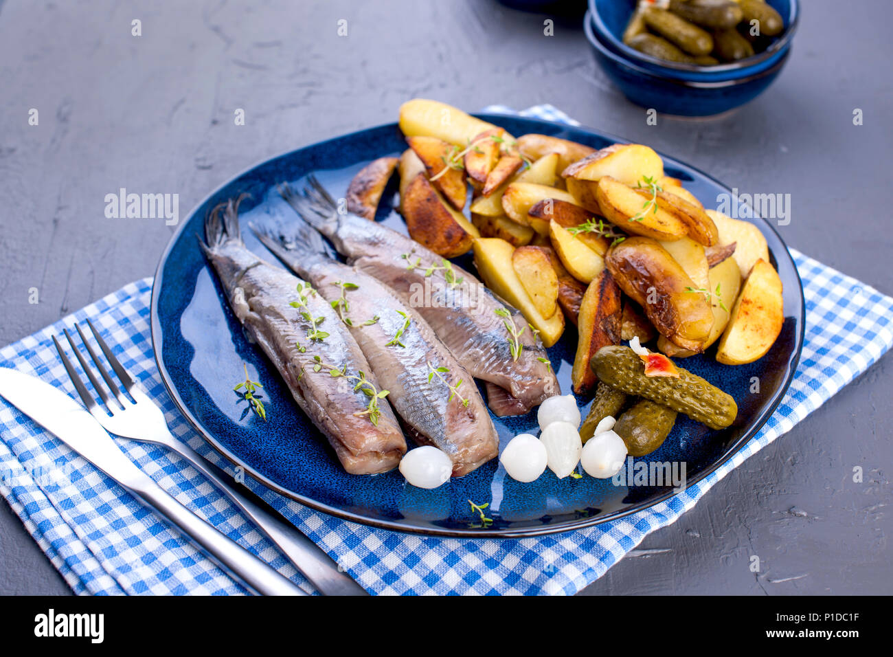 Herring fillets on a plate, baked in the oven potatoes and pickled