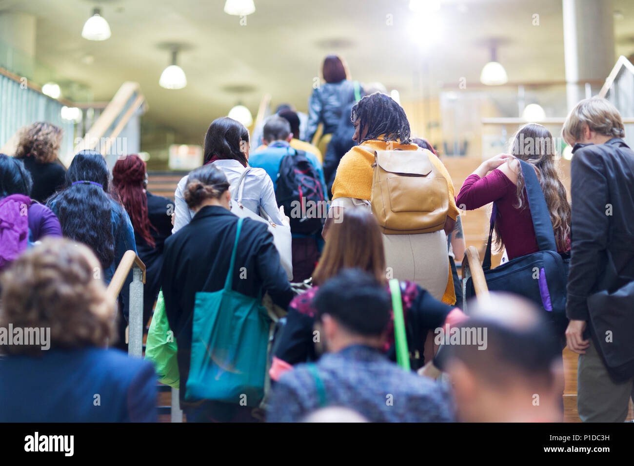 Crowd of people with backpacks and bags climbing stairs Stock Photo