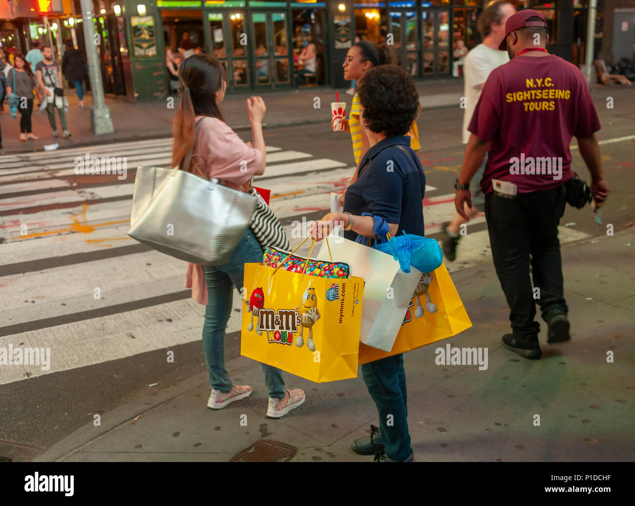 Asian tourists with their M&M shopping bags in New York on Tuesday, May 29, 2018 (Â© Richard B. Levine) Stock Photo