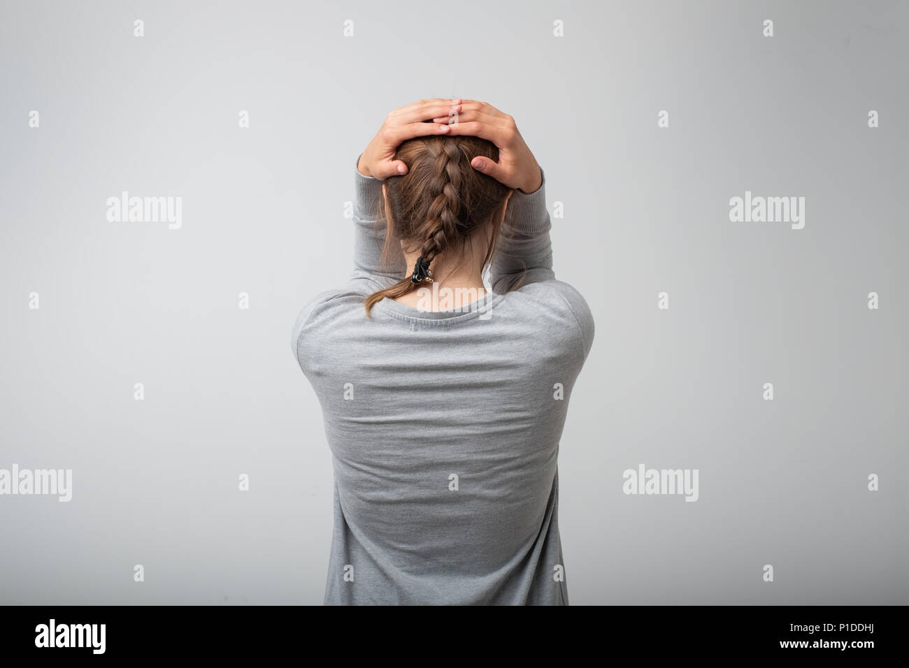 Crying standing young woman, back view Stock Photo