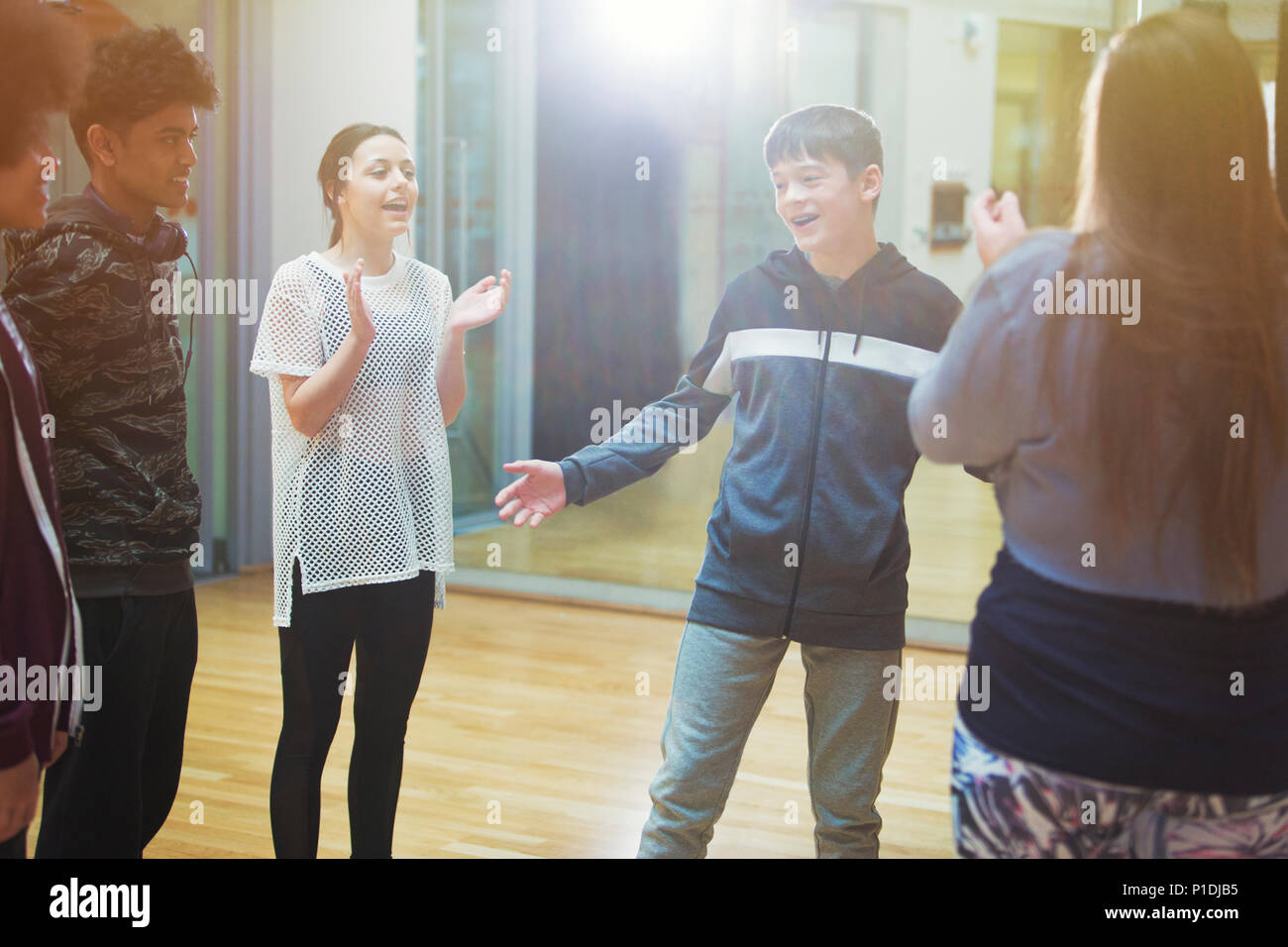 Classmates clapping for teenage boy in dance class studio Stock Photo