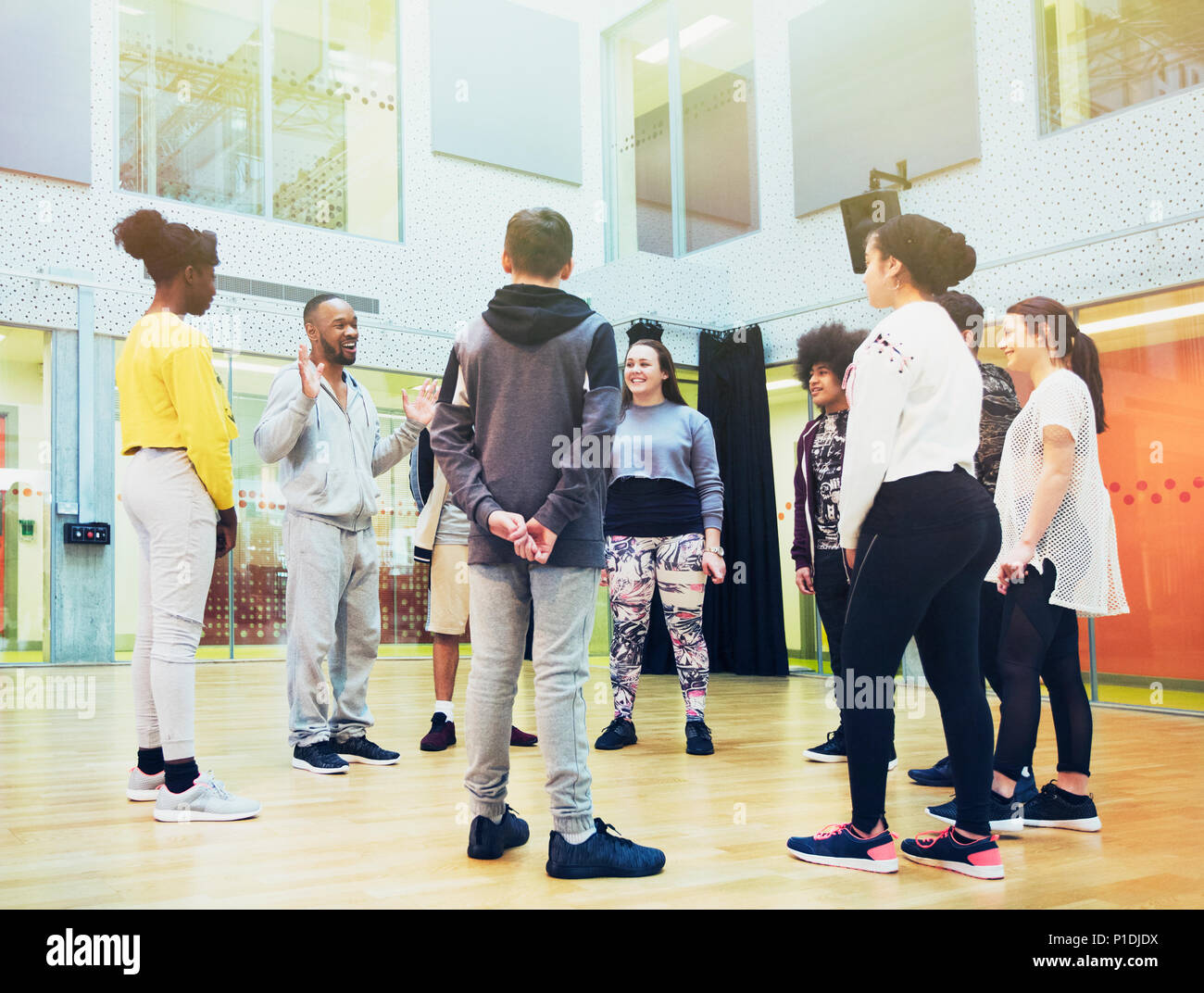 Teenage students listening to male instructor in dance class studio Stock Photo