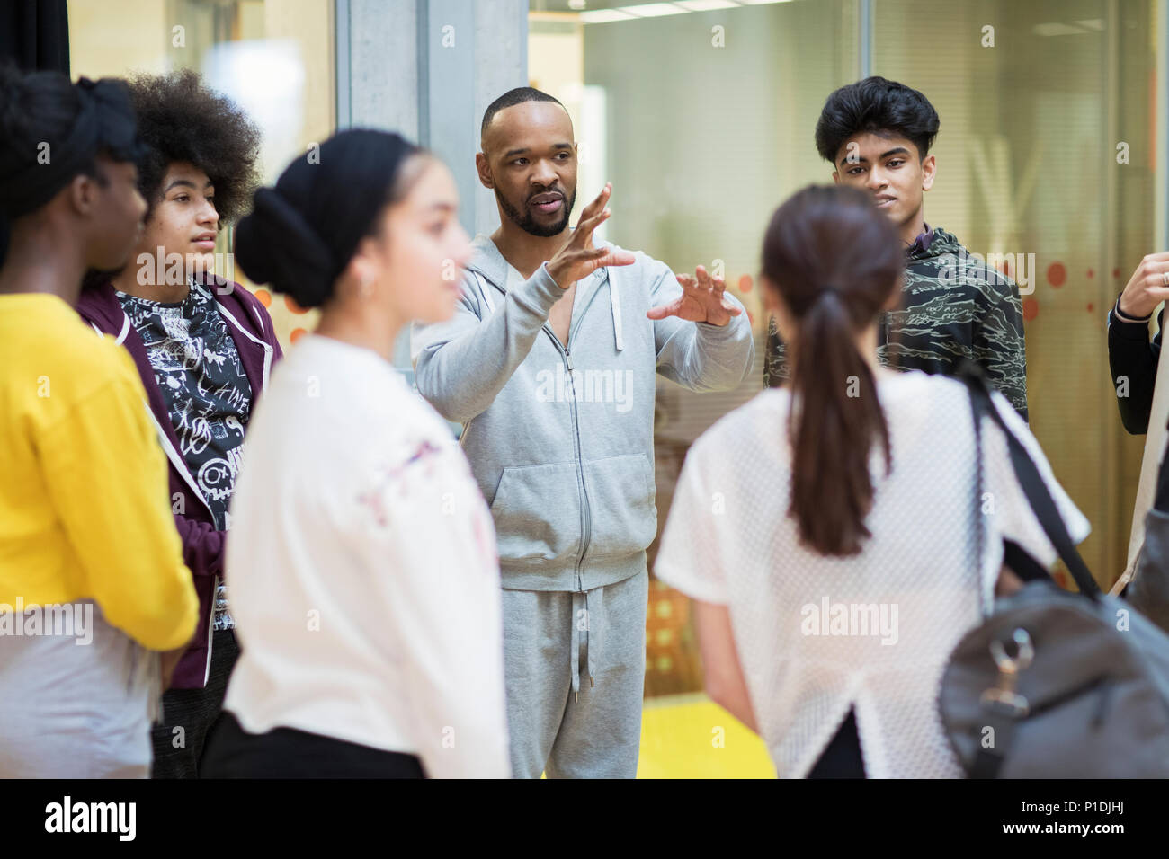 Male instructor leading teenagers in dance class studio Stock Photo
