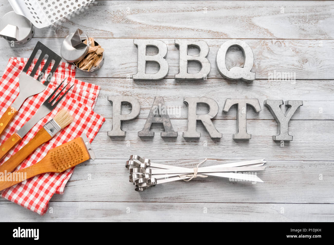 BBQ Party sign with BBQ cooking tools on a wood background Stock Photo