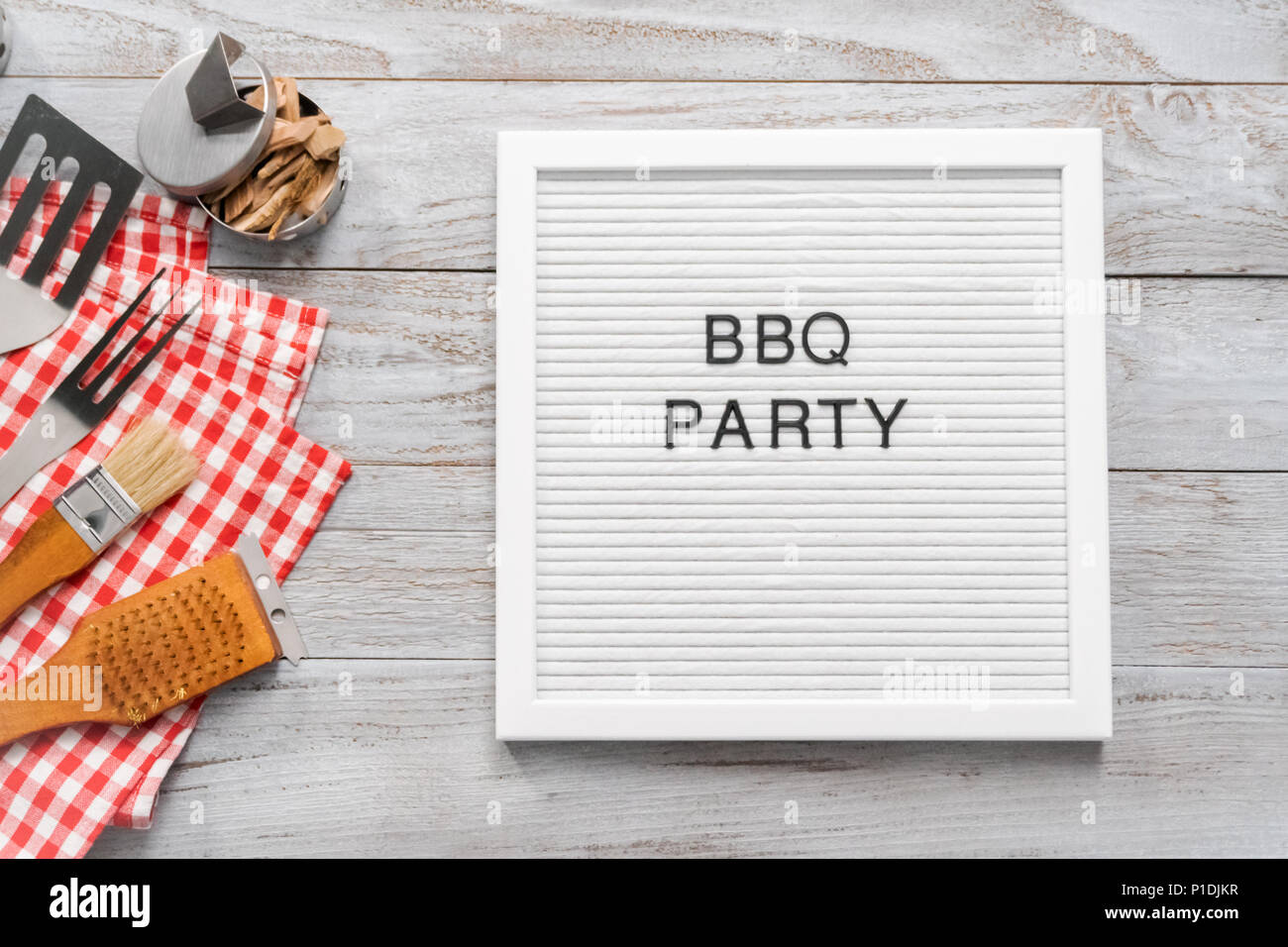 BBQ Party sign with BBQ cooking tools on a wood background Stock Photo