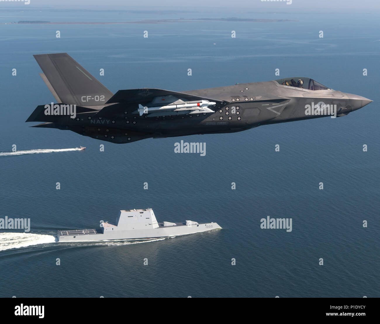 An F-35 Lightning II Carrier Variant (CV) piloted by U.S. Marine Corps Maj. Robert 'Champ' Guyette II, a test pilot from the F-35 Pax River Integrated Test Force (ITF) assigned to the Salty Dogs of Air Test and Evaluation Squadron (VX) 23, flies over the stealth guided-missile destroyer USS Zumwalt (DDG 1000) as the ship transits the Chesapeake Bay on Oct. 17, 2016. USS Zumwalt, the Navy's newest and most technologically advanced surface ship, joined the fleet Oct. 15. The F-35C Lightning II — a next generation single-seat, single-engine strike fighter that incorporates stealth technologies, d Stock Photo