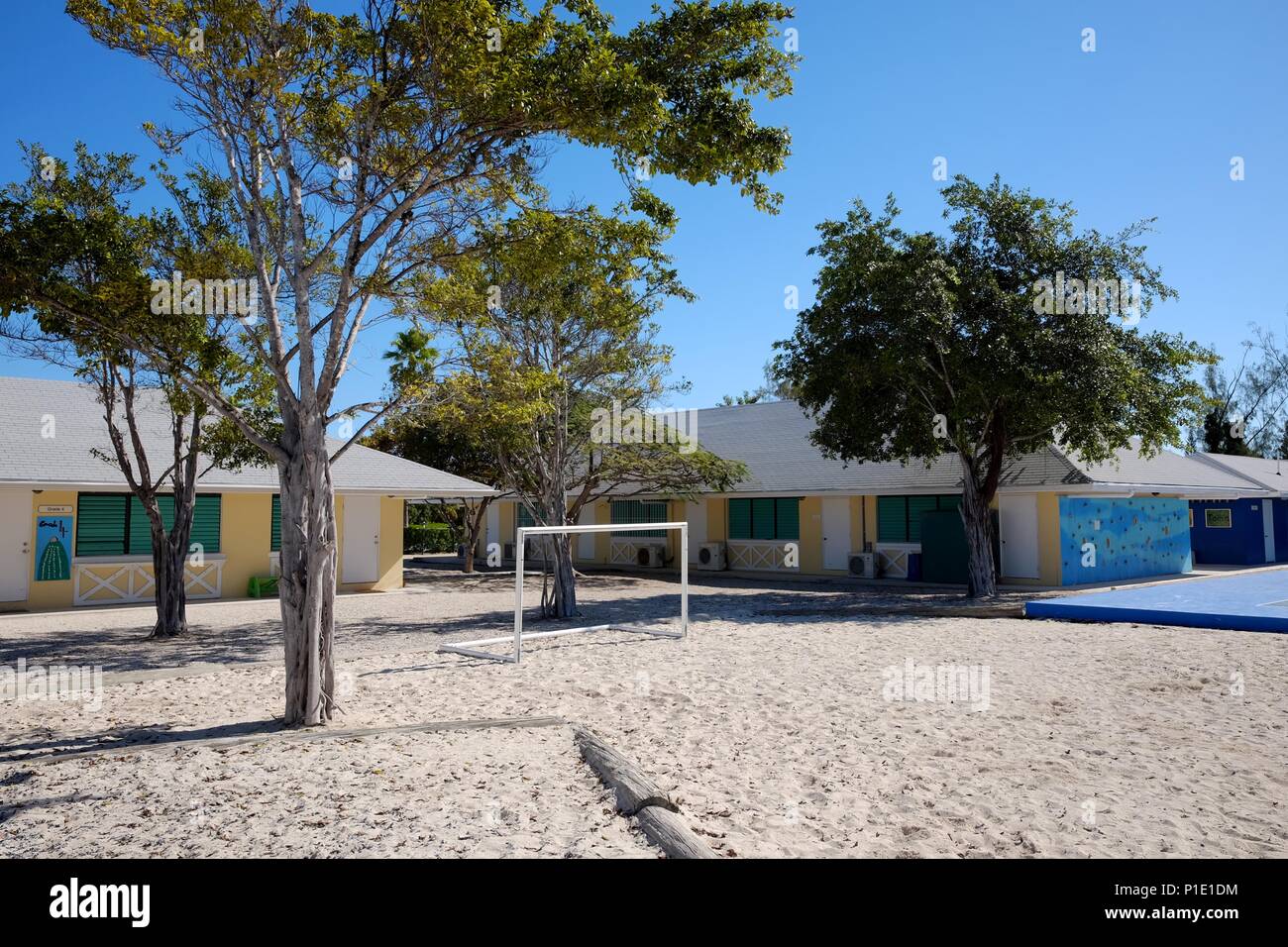 Football (soccer) goalposts among sand, buildings and trees on a bright and sunny day Stock Photo