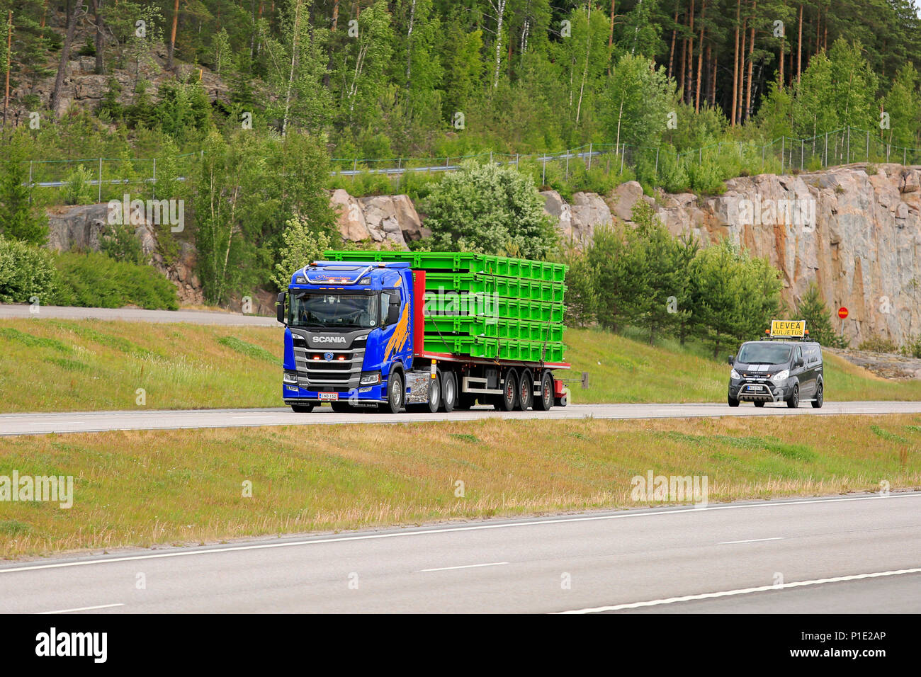 Oversize load transport by Scania R500 semi trailer of Nurminen followed by escort car on freeway in the summer in Paimio, Finland - June 8, 2018. Stock Photo