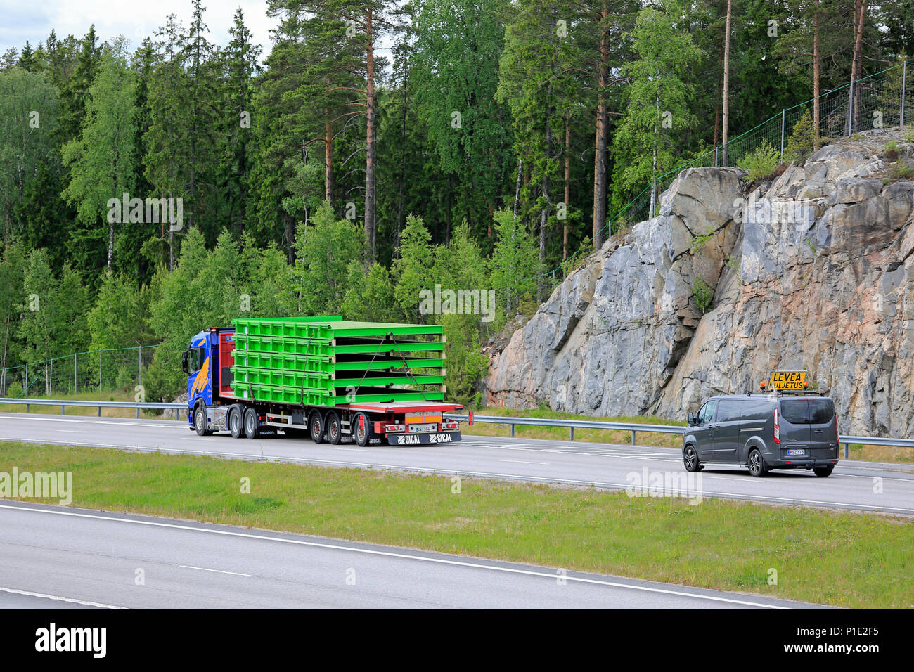 Oversize load transport of industrial objects by Scania R500 semi trailer of Nurminen followed by escort car on freeway in the summer in Paimio, Finla Stock Photo