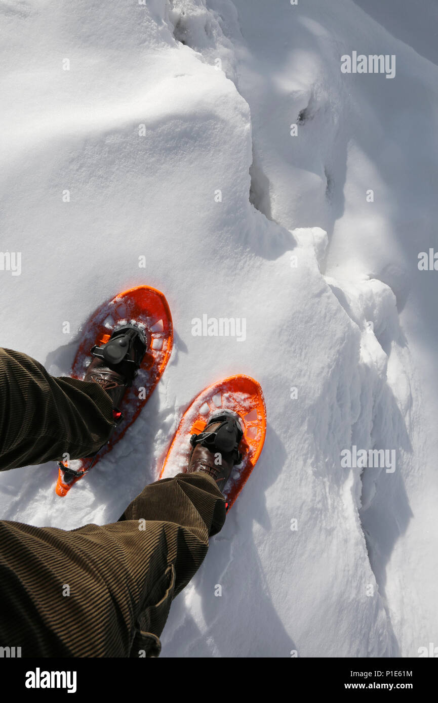 Reckless hiker with orange snowshoes and velvet pants on the edge of a  crevasse in the glacier in the mountains Stock Photo - Alamy