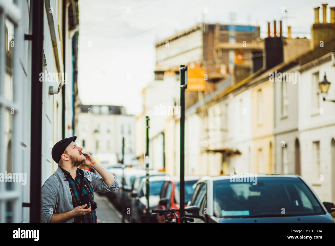 Man on street looks into the sky, Brighton, England Stock Photo