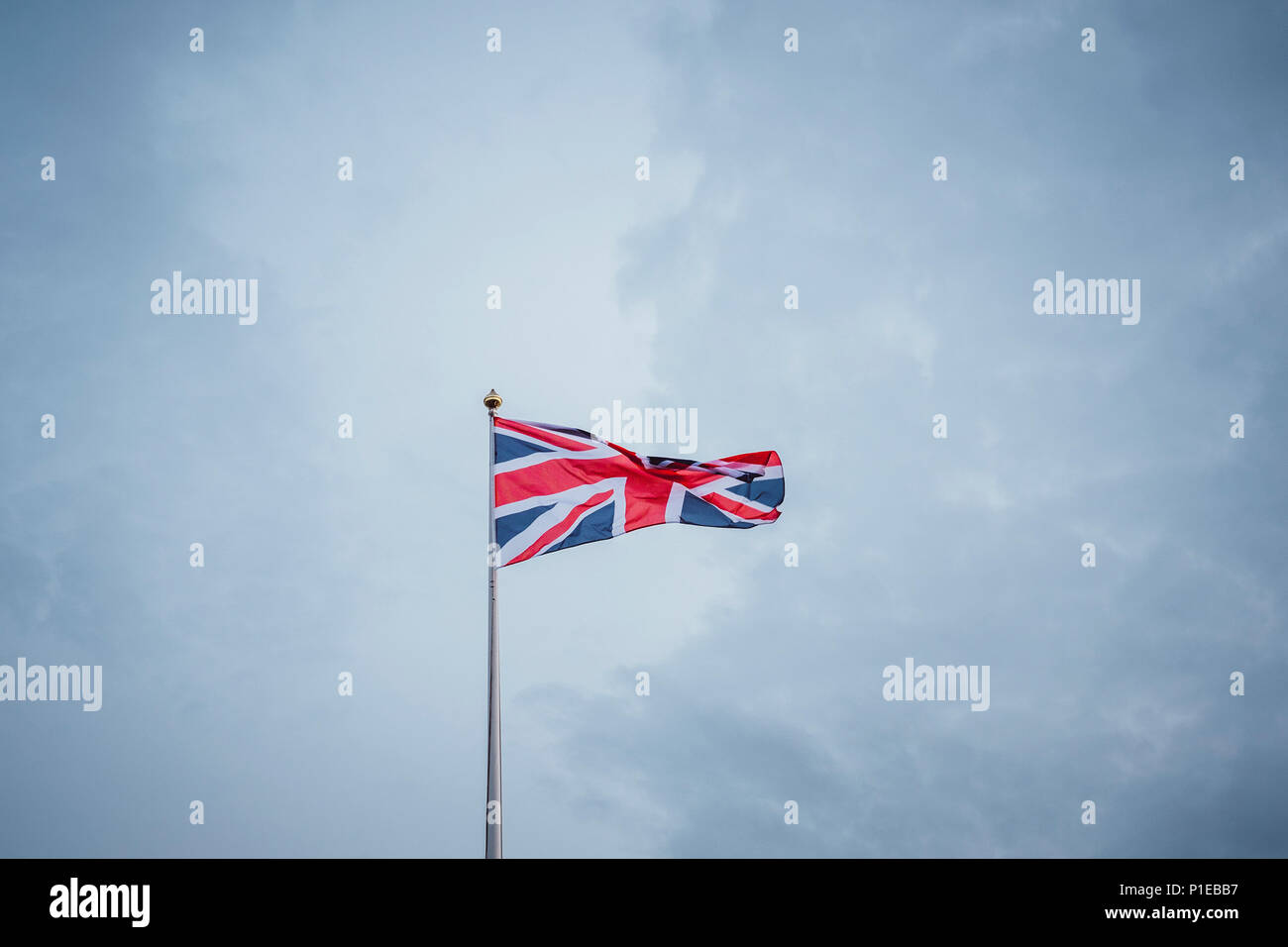 Waving flag in front of blue sky, United Kingdom Stock Photo