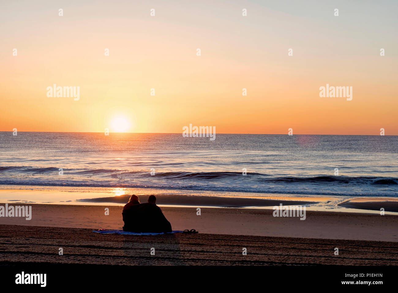 Beach morning sunrise with couple Stock Photo