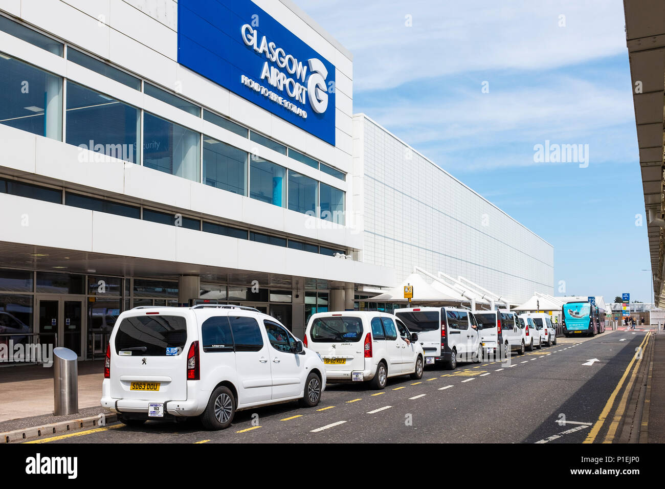 Main entrance to Glasgow International airport with the iconic white taxis at the taxi rank