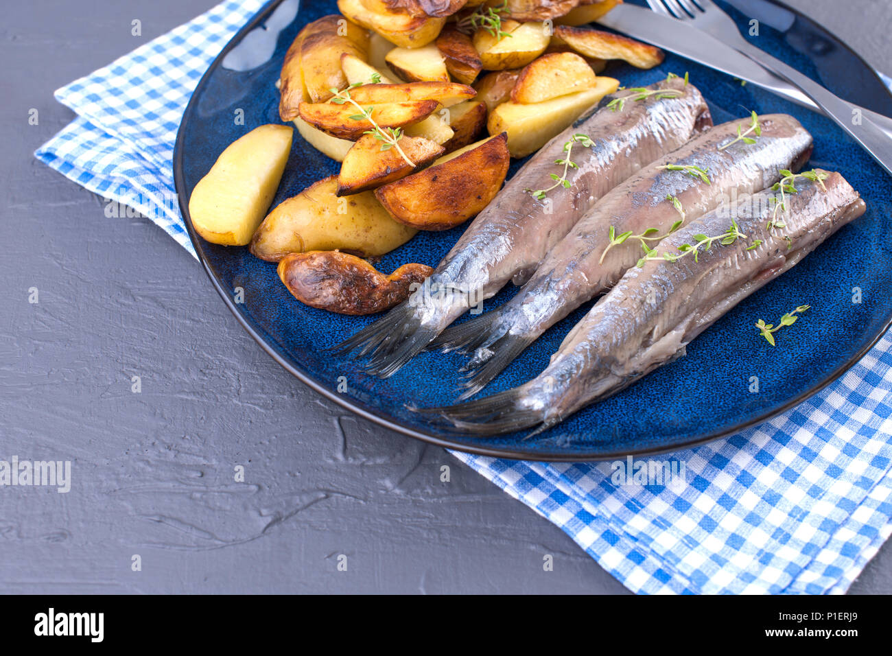 Fillet of herring on a plate and baked in the oven potatoes. Delicious traditional food of