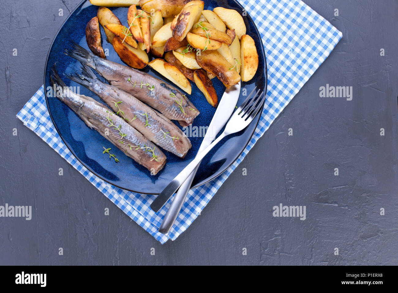 Fillet of herring on a plate and baked in the oven potatoes. Delicious traditional food of