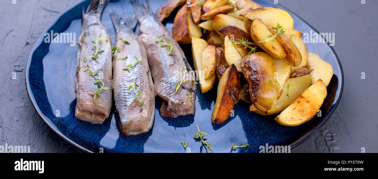 Fillet of herring on a plate and baked in the oven potatoes. Delicious traditional food of