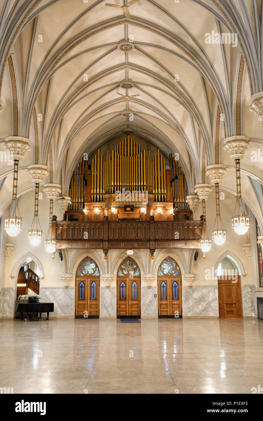 Church hall with stunning interior architecture, highly decorative ceiling arches, and pipe organ loft at rear, antique building circa 1904. Stock Photo