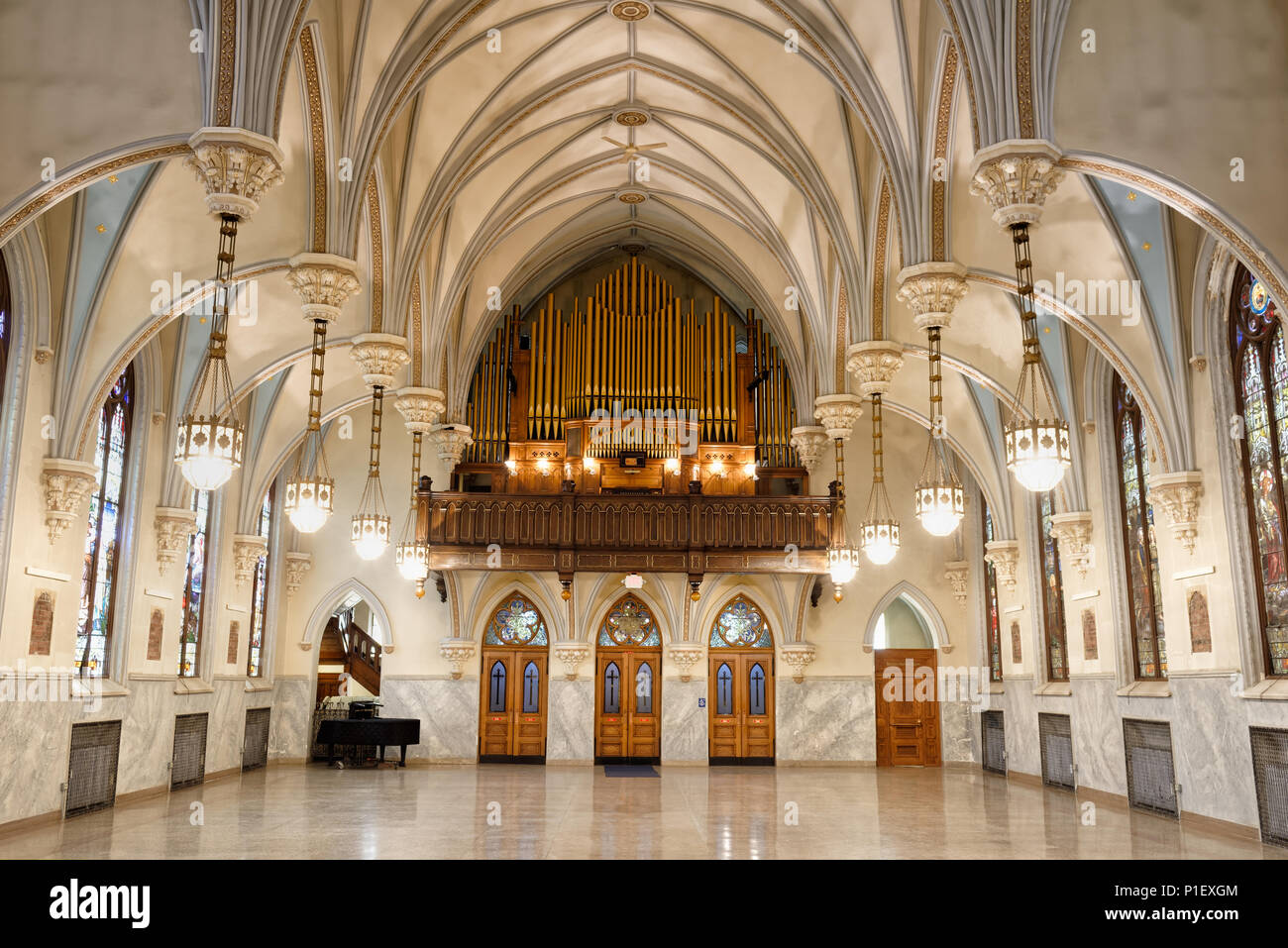 Church hall with stunning interior architecture, highly decorative vaulted ceiling arches, and pipe organ loft at rear, antique building circa 1904. Stock Photo