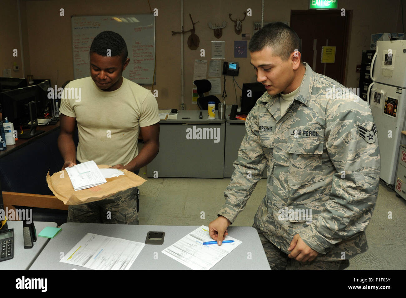 Senior Airman Nicholas Contreras, left, 386th Expeditionary Logistics Readiness Squadron materiel management journeyman, passes off an aircraft part to be shipped to Senior Airman Dominique Corbin, 386 ELRS traffic management journeyman, Oct. 13, 2016 at an undisclosed location in Southwest Asia. The APS coordinates with TMO to send needed parts to locations throughout the area of responsibility. (U.S. Air Force photo/Senior Airman Zachary Kee) Stock Photo
