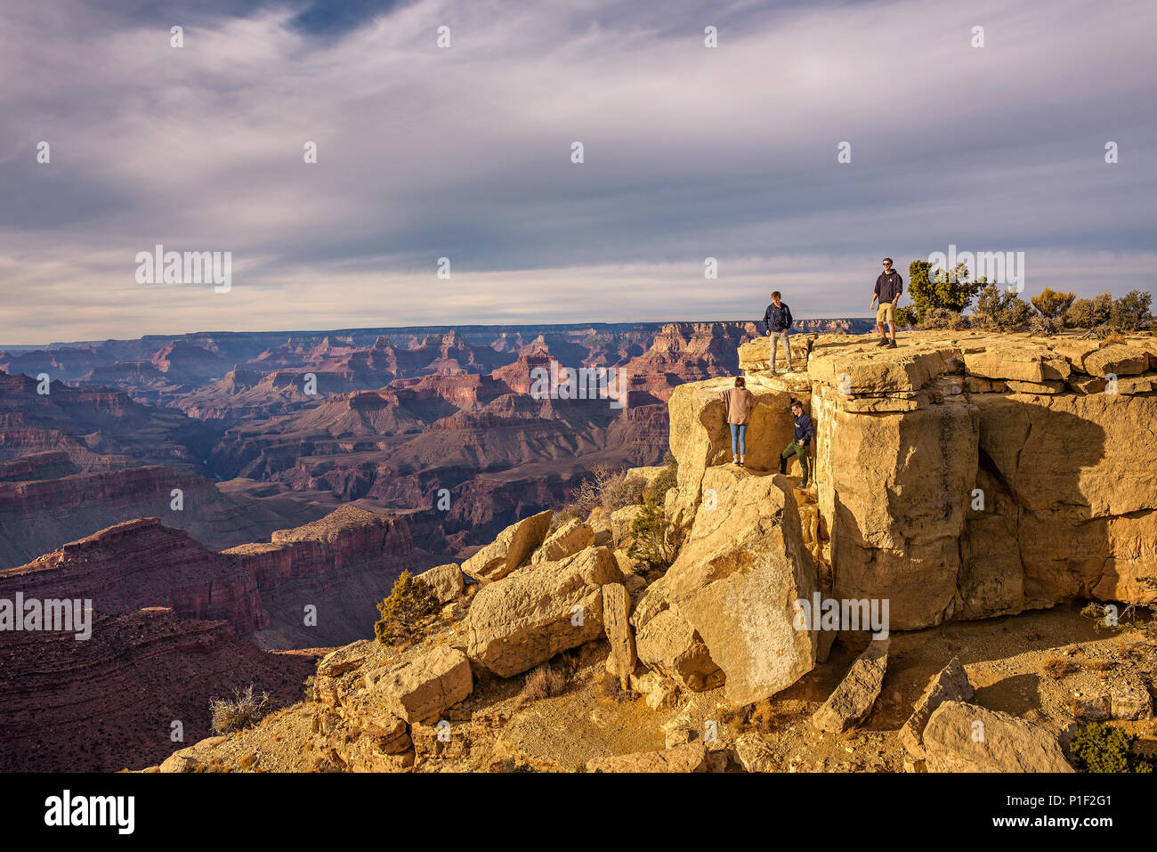 Tourists climbing the big rocks of Grand Canyon National Park Stock Photo