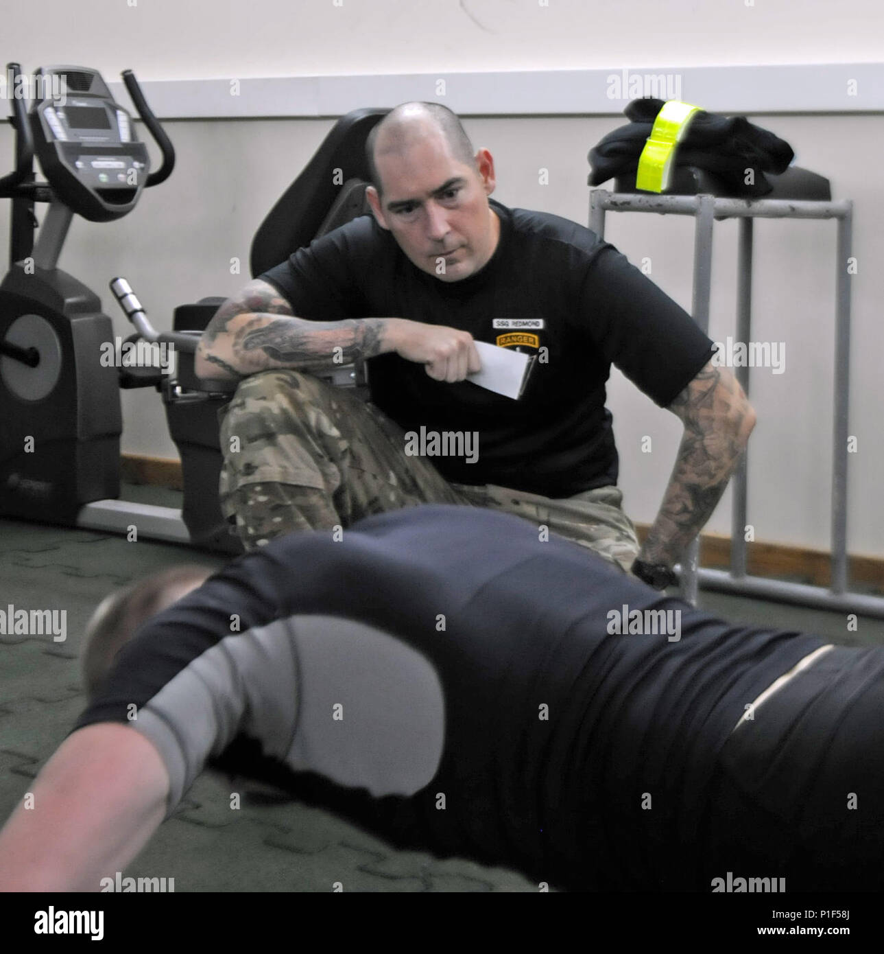 RUKLA, Lithuania – Staff Sgt. Ian Redmond, a Reconnaissance and Surveillance Leader’s Course instructor from Delta Company 3rd Squadron, 16th Cavalry Regiment, counts as Estonian Cpl. Algis Petrov does push-ups Oct. 26 during the Army Physical Fitness Test as part of the course. The course is being hosted by 2nd Battalion, 503rd Infantry Regiment, 173rd Airborne Brigade in Lithuania and features Paratroopers from their unit, as well as soldiers from Estonia, Latvia, Lithuania, Poland and Slovakia. Stock Photo