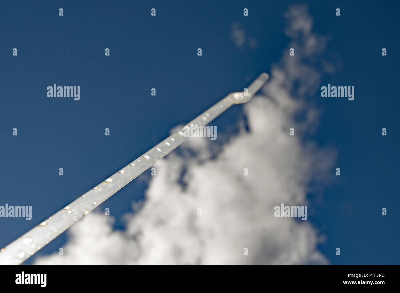 Drinking straw like a trajectory into the cloudy sky. Stock Photo