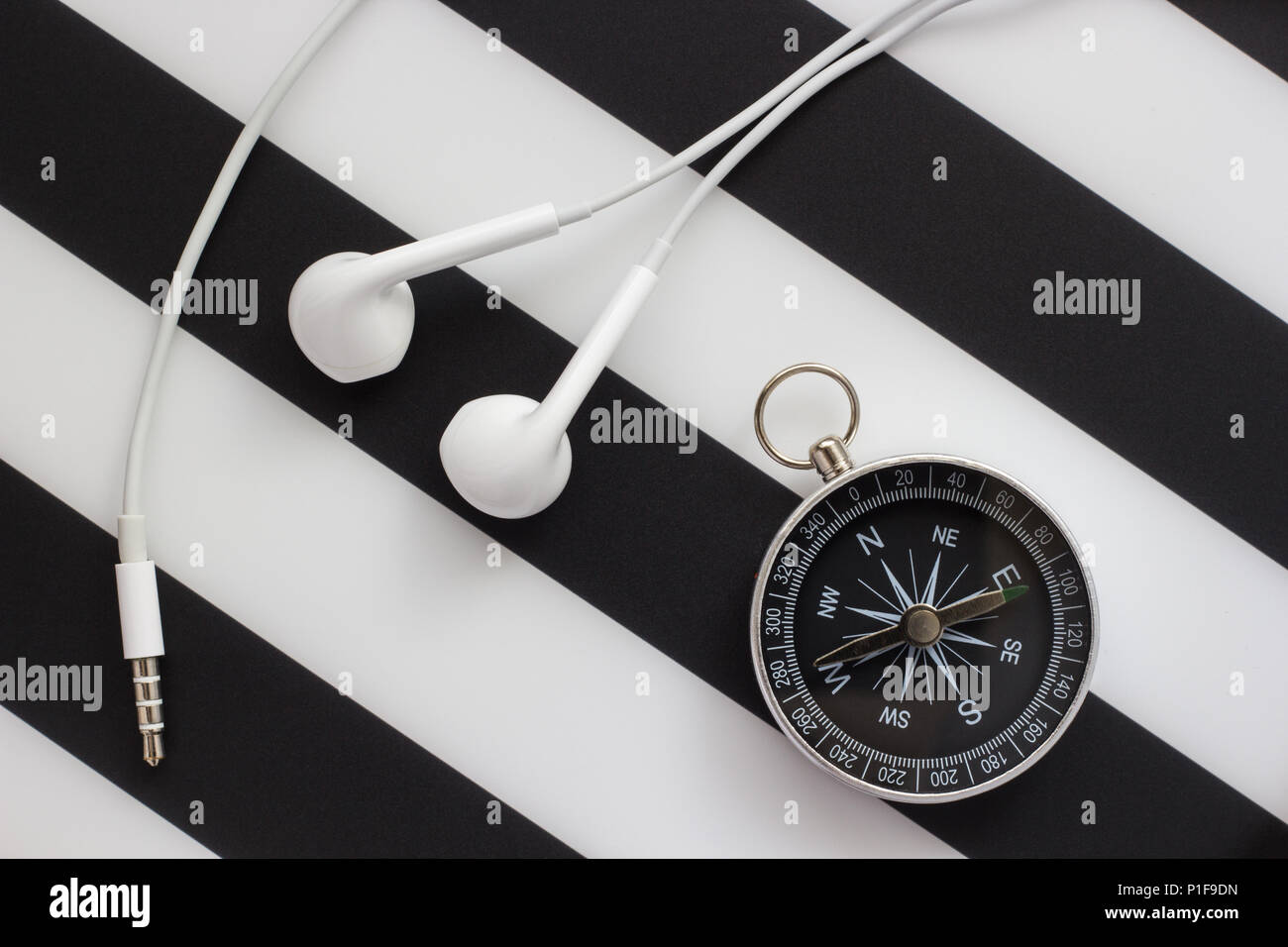headphones and compass on black and white background, close-up Stock Photo