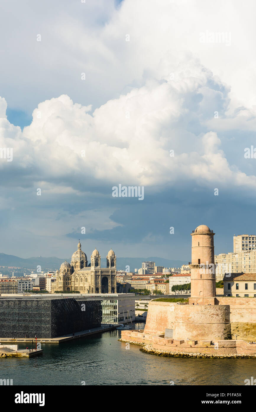 Saint Jean fort in Marseille under a stormy sky with the MuCEM and Villa Mediterranee buildings and Sainte Marie Majeure cathedral in the distance. Stock Photo