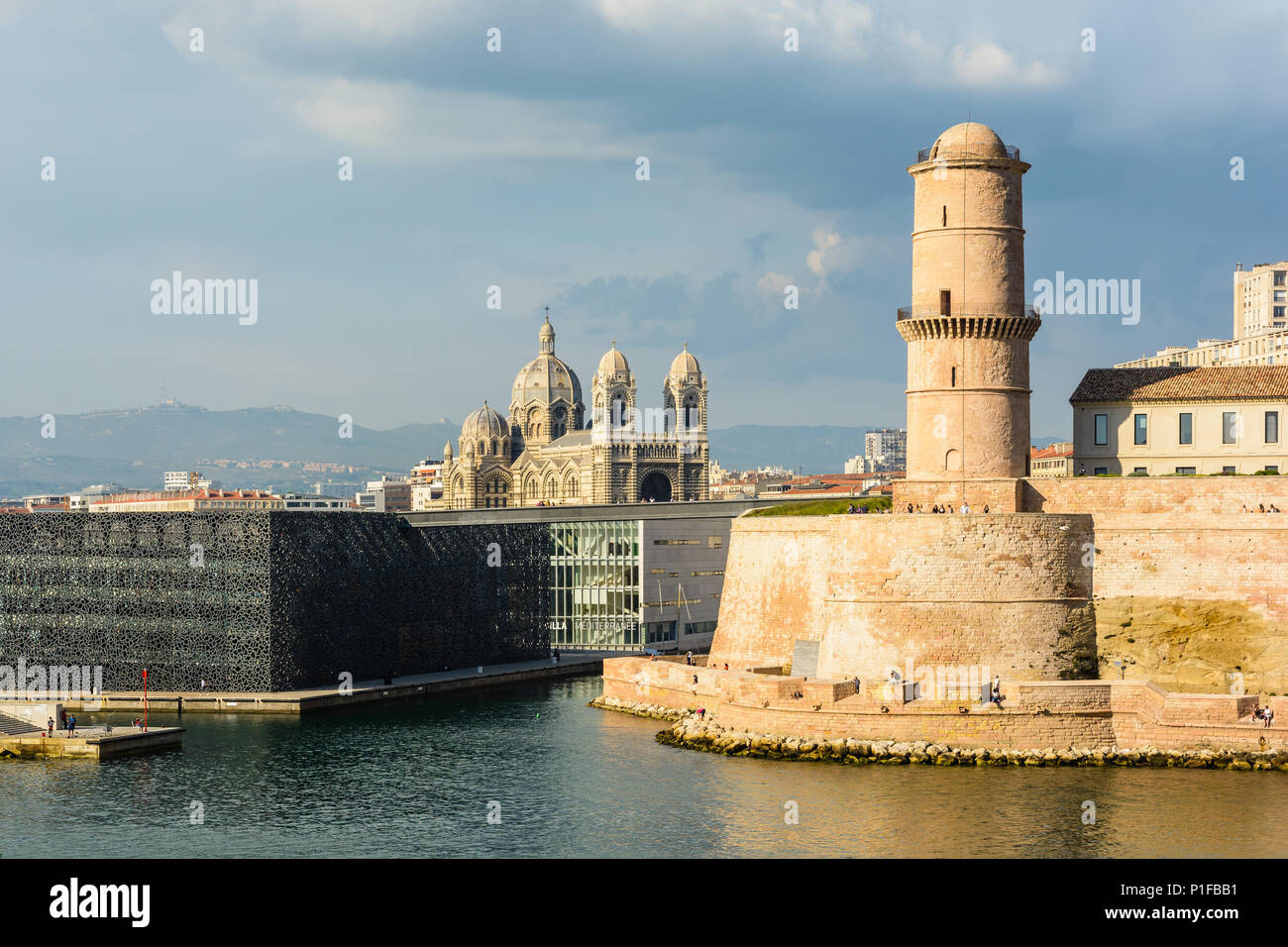 Saint Jean fort in Marseille under a stormy sky with the MuCEM and Villa Mediterranee buildings and Sainte Marie Majeure cathedral in the distance. Stock Photo
