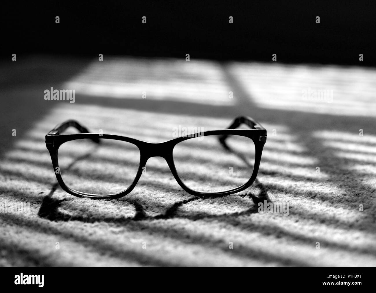 Reading glasses in the light and shadows. Stock Photo