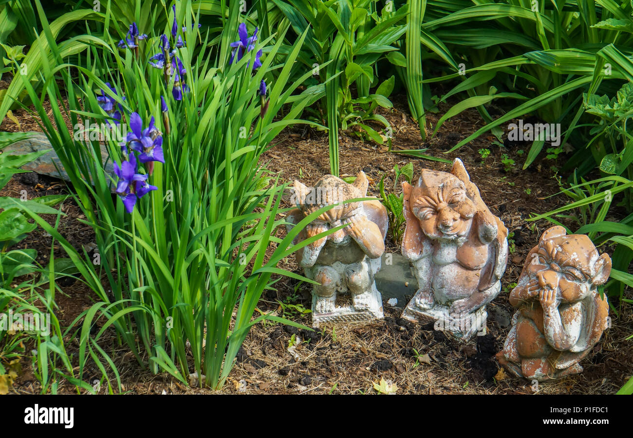 garden figures of animals representing the saying: see no evil, say no evil, hear no evil Stock Photo