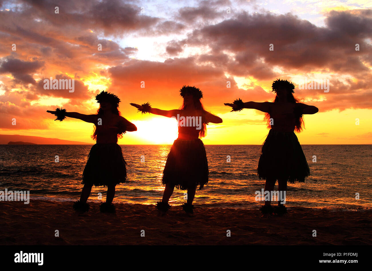 Three hula dancers at sunset at Palauea Beach, Maui, Hawaii. Stock Photo